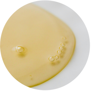 Nahaufnahme eines goldenen Naturöls mit feinen Luftblasen.